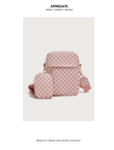 Pink crossbody bag detail with textured geometric pattern and a round coin pouch charm