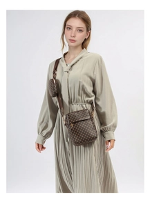 Brown monogram shoulder bag with mini round coin purse shown on a sage green dress