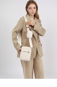 Detail of cream monogram crossbody shoulder bag with detachable mini pouch and woven strap