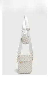 Detail view of the pink patterned shoulder bag with detachable mini round pouch and strap