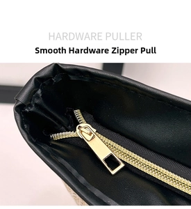 Close-up of smooth golden hardware puller and zipper on black textured straw bag