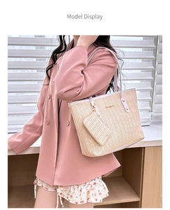 Beige straw tote bag with pink leather straps and mini pouch worn by model