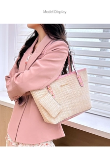 Detail of straw woven tote with pink leather trim and matching mini bag charm