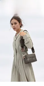 Sac bandoulière vintage marron à monogramme avec pochette porté par un mannequin
