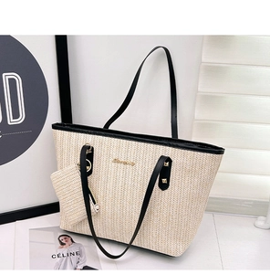 Close-up of woven straw tote bag with black leather trim and mini pouch accessory