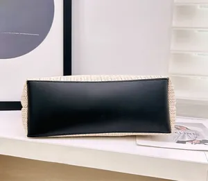 Detail of reinforced black faux leather base and beige woven texture on the straw bag