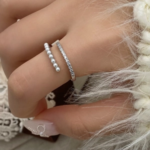 Close-up of double-layer silver ring with small pearls and sparkling zircon stones
