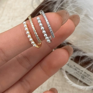 Macro shot of three elegant ear cuff designs featuring small pearls and sparkling zircons