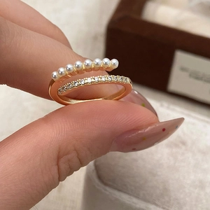 Detail of gold layered open ring with small pearls and sparkling zircon pavé