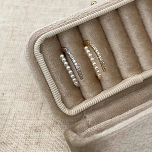 Close-up of double layer open rings with micro pearls and sparkling zircons in gold and silver
