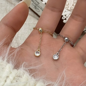 Close-up of adjustable chain rings in gold and silver with sparkling round cubic zirconia