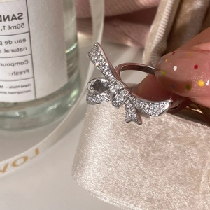 Detailed close-up of a silver bow ring featuring micro-paved sparkling cubic zirconia