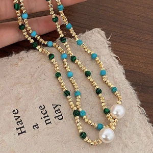 Collier de perles dorées avec turquoise et perles sur une carte Have a nice day