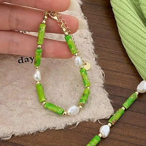 Green stone and freshwater pearl necklace with gold accents for a vintage vacation look
