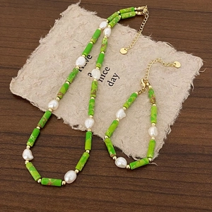 Detailed close-up of green natural stones and freshwater pearls on necklace and bracelet