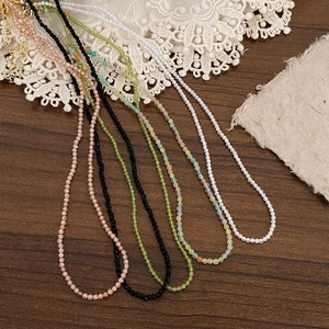 Double-layered beaded necklace set with green zircon stones and faceted tiny beads