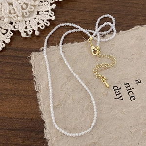 Detail of beaded necklace with gold lobster clasp and adjustable extension chain