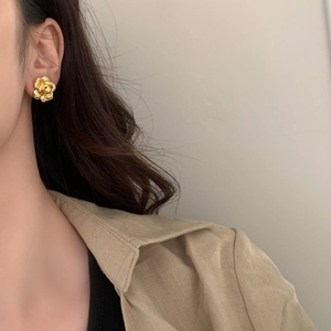 Elegant gold petal stud earrings with a 3D camellia design shown on a model