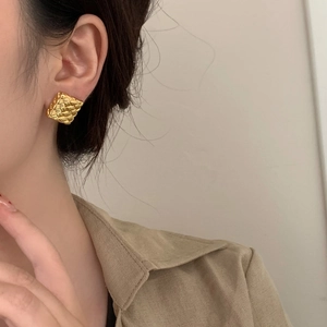 Élégantes boucles d'oreilles carrées tressées dorées pour femmes portées par un mannequin