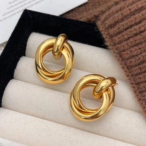 Elegant gold multi-layered twisted hoop earrings displayed in a luxury jewelry box