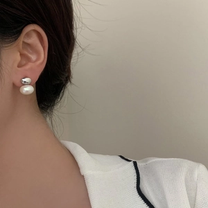 Détail de boucles d'oreilles pendantes vintage en perles sur l'oreille avec clou argent