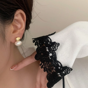 Boucles d'oreilles vintage françaises en métal doré et perle blanche portées par un mannequin