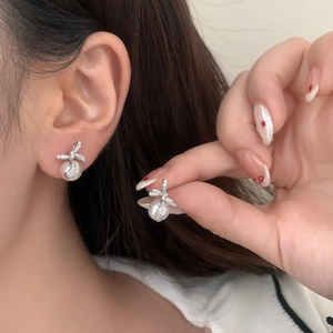Boucles d'oreilles élégantes en perles avec nœud argenté et zircons cubiques brillants