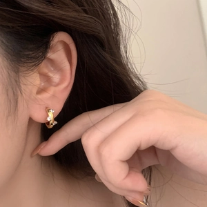 Elegant gold hoop earrings with three sparkling zircons shown on a female model