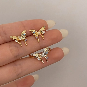 Detailed shot of golden bow butterfly earrings and ring set with colorful zircon stones