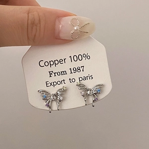 Detailed close-up of butterfly stud earring with blue purple zircon inlay and copper base