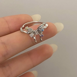 Detailed close-up of a silver butterfly ring with colorful gemstone wing accents