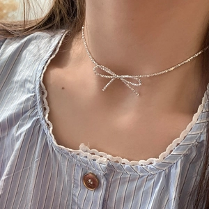 Elegant silver bow pendant necklace with shimmering textured beads for women