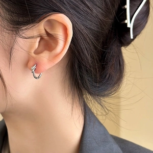 Minimalist silver knot hoop earrings for women showing polished metallic finish