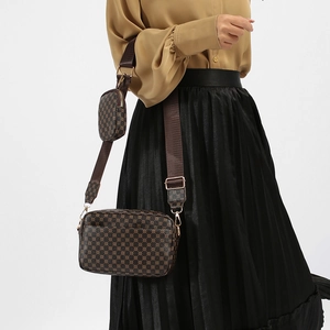 Crossbody bag with vintage pattern, small round coin purse, and wide strap on model