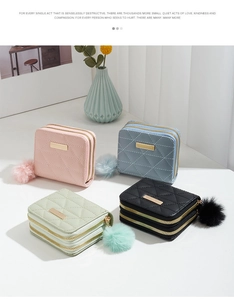 Detail of multi-color quilted leather wallets with gold accents and soft pompom charms