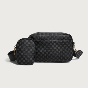 Detail of grey crossbody bag set with geometric monogram pattern and wide shoulder strap