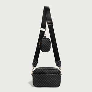 Detail of black printed crossbody bag with gold hardware and small round pouch attachment