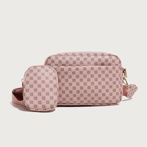 Close-up of pink camera bag set with floral print and gold metal hardware detail