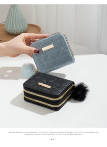 Close-up of dual zipper quilted mini wallets with chic faux fur pompom keychain detail