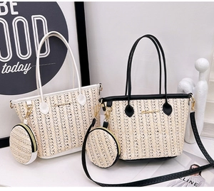 Dettaglio della borsa tote in paglia intrecciata con finiture in pelle e portamonete tondo