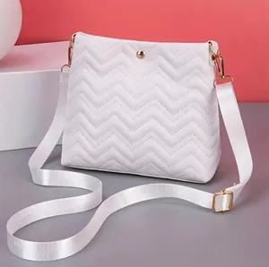 Modern white wave-quilted crossbody bag with pearl cat charm and gold hardware