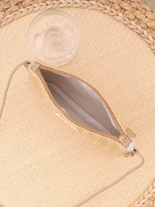Close-up of woven straw bag interior with white fabric lining and golden metal zipper
