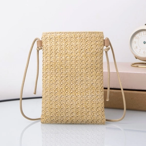 Detail of hand-woven straw mini crossbody bag with natural texture and rope strap