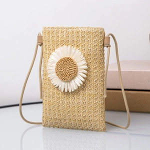 Close-up of hand-woven straw crossbody phone bag with a large white daisy flower detail