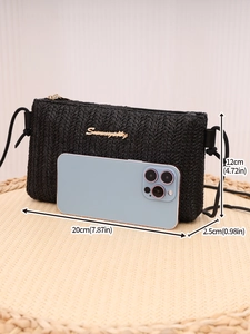 Detailed size view of black woven crossbody bag with dimensions and phone for scale
