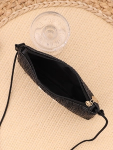 Detail view of woven black crossbody bag with metal zipper and soft interior lining