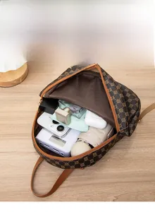 Interior detail of a brown patterned backpack showing multiple compartments and high capacity