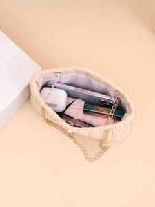 Interior view of beige woven chain bag showing capacity for phone and cosmetics