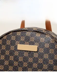 Close-up of floral pattern faux leather material and gold-tone hardware on coin bag