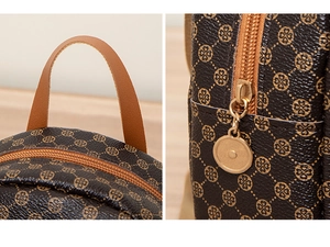 Macro detail of brown leather backpack with golden clover pattern and metal zipper